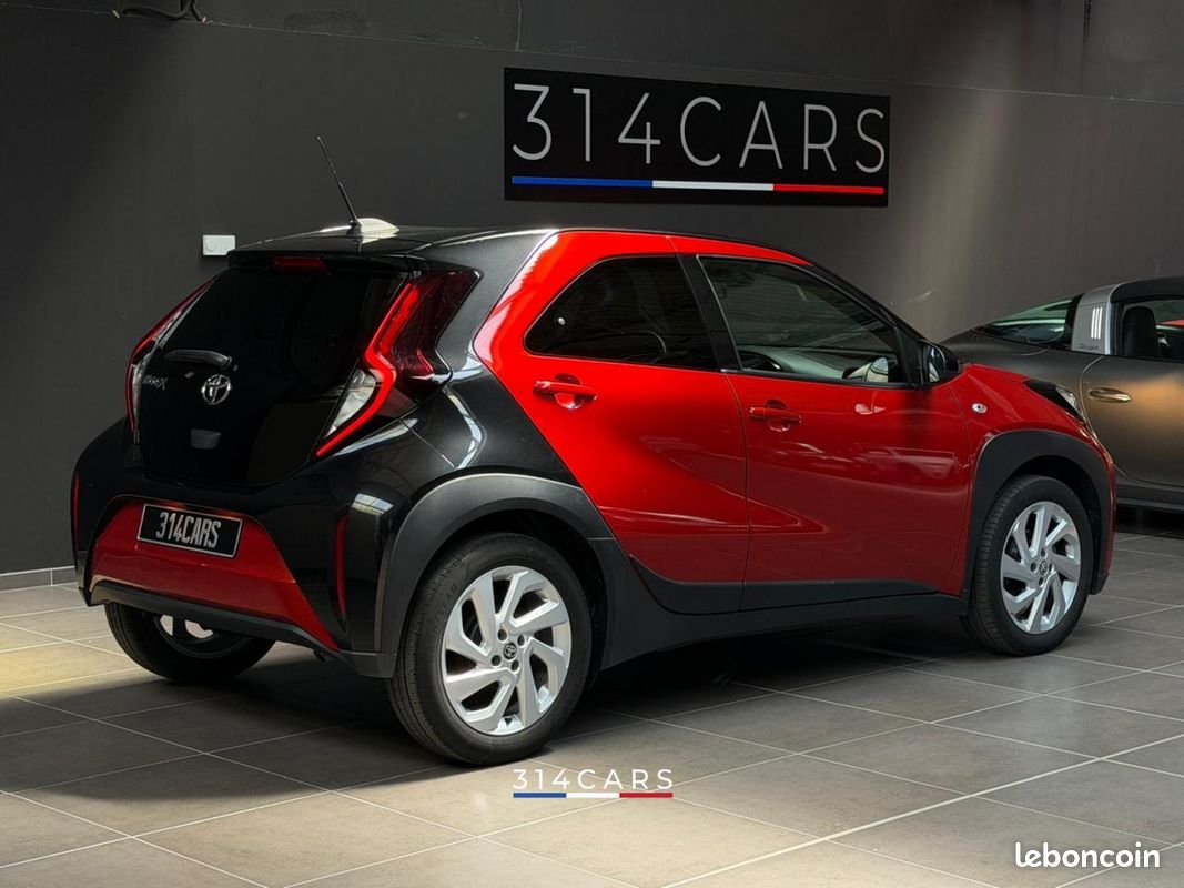 Toyota Aygo X rouge vue de trois quarts arrière dans le showroom 314CARS